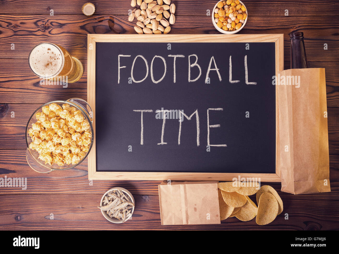 football fans concept of beer bottle in brown paper bag, chips