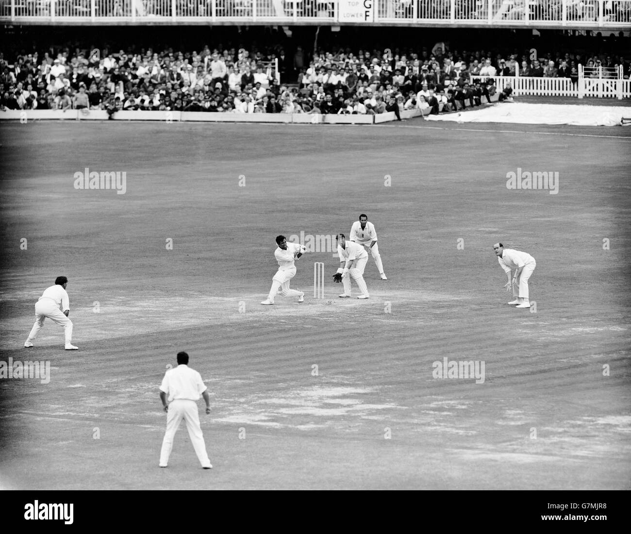 Pakistan's Asif Iqbal (third l) pulls the ball to the boundary, watched by England's Brian Close (r), Basil D'Oliveira (second r) and John Murray (third r) Stock Photo