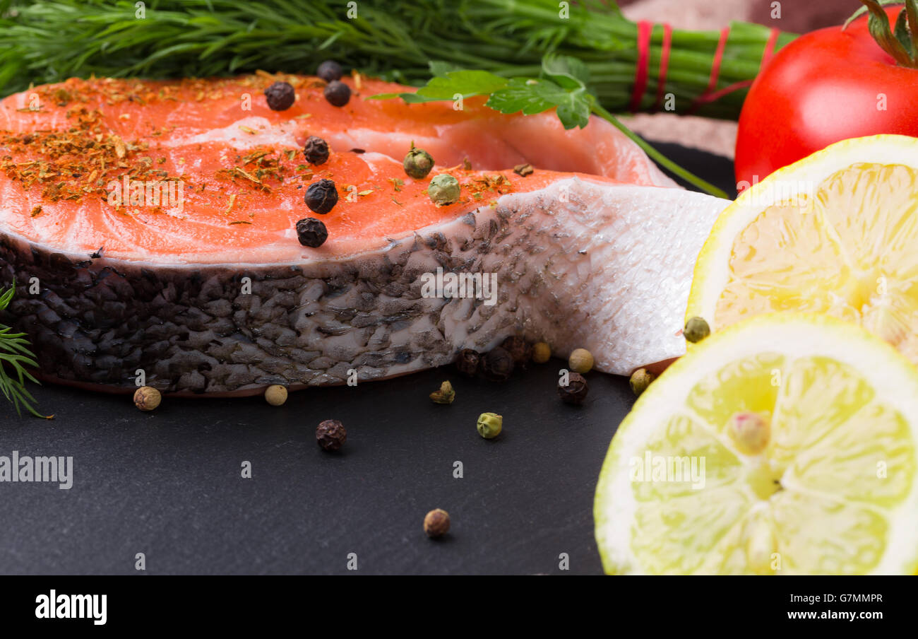 red fish steak with spices on a slate plate. Stock Photo