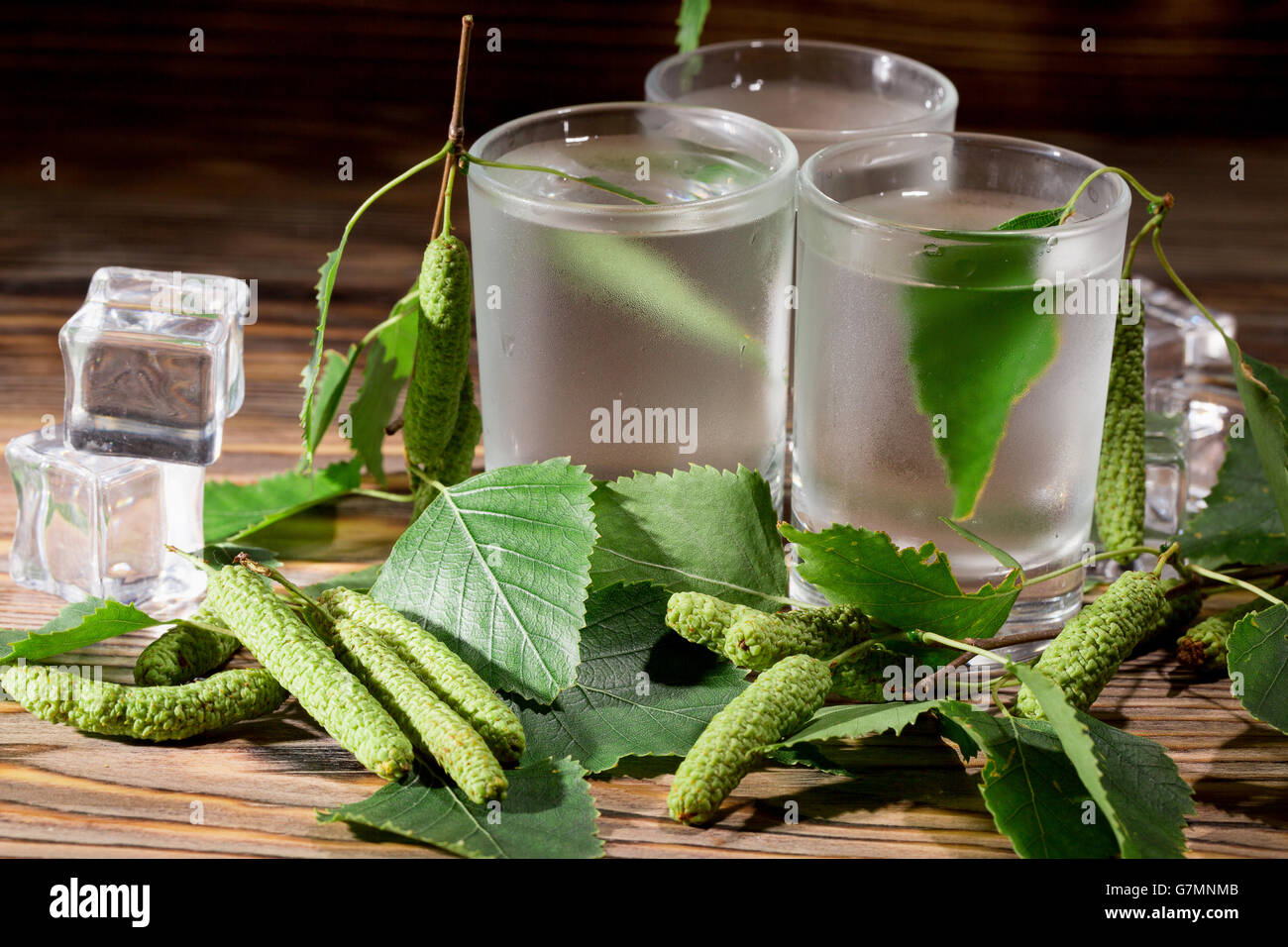 cold vodka on birch buds on the wooden background. Stock Photo