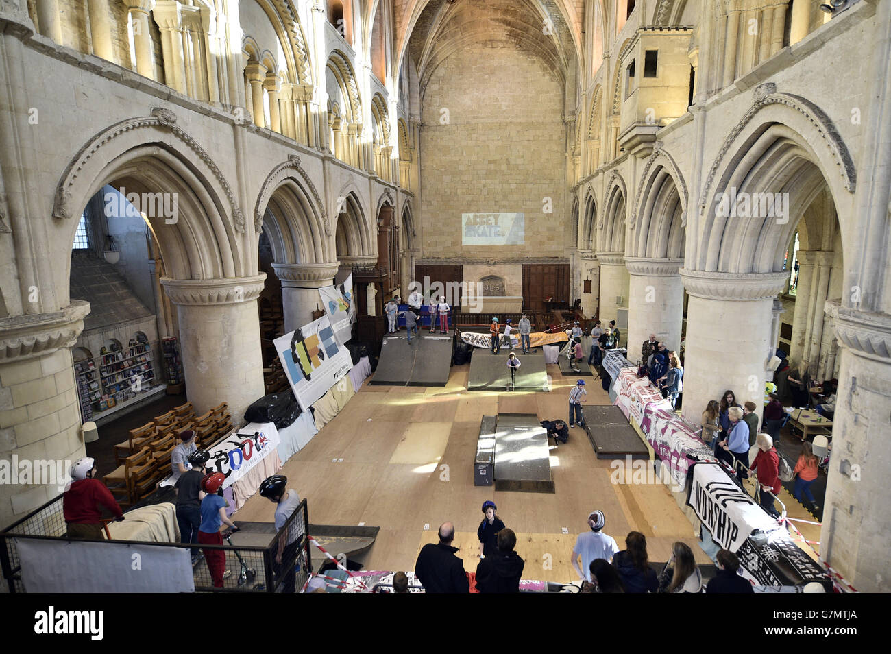 Skaters and scooter enthusiasts enjoy a temporary skate park that has been set up inside Malmesbury Abbey, Wiltshire, as the annual event sees skaters come inside the 12v Abbey to pull tricks and ride over jumps and ramps. Stock Photo