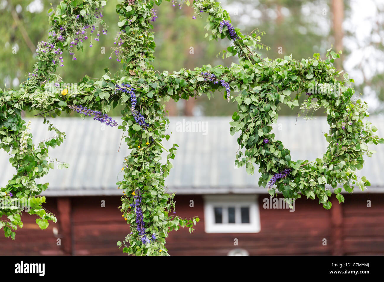 Swedish Traditional Midsummer Pole (Maypole) with a building in the background. Stock Photo