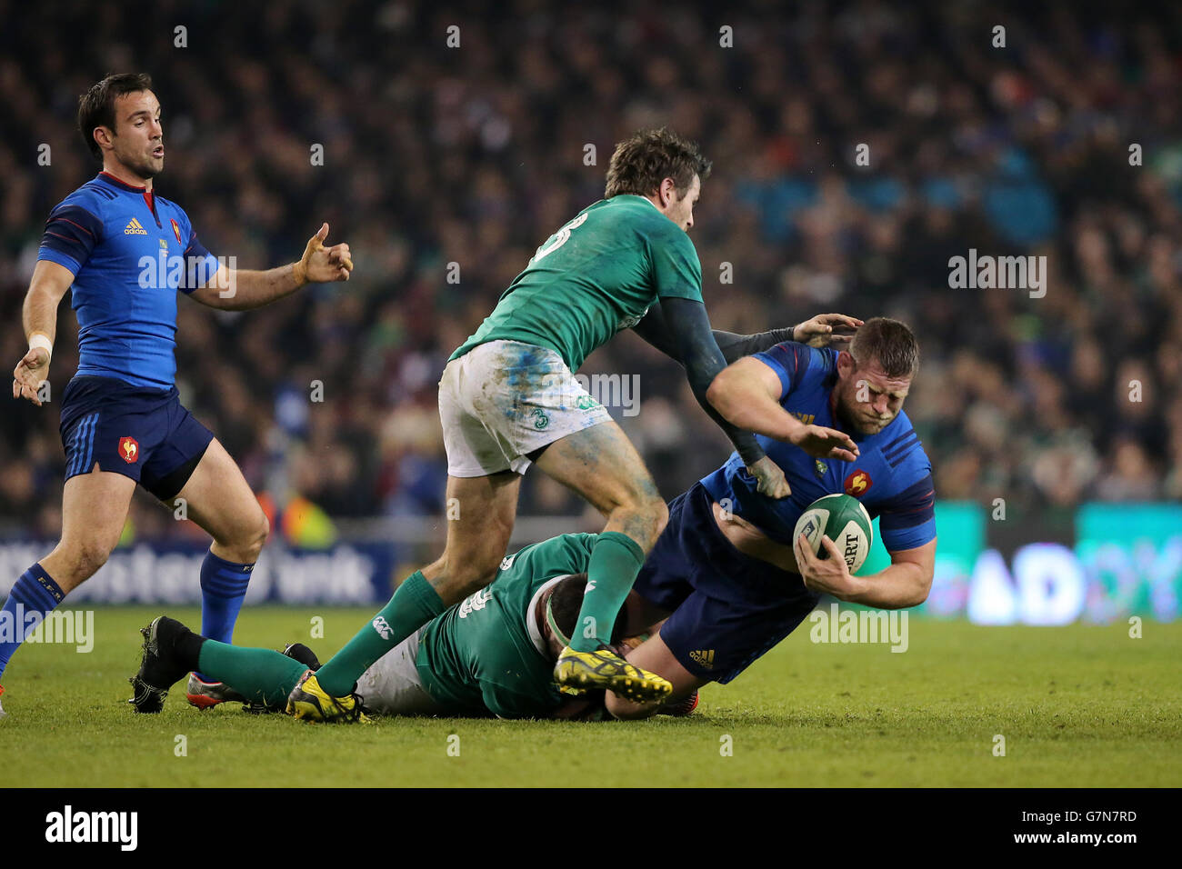 France's Vincent Debaty (centre) is tackled by Ireland's Jared Payne (right) and Martin Moore (floor) during the 6 Nations match at Aviva Stadium, Dublin. Stock Photo