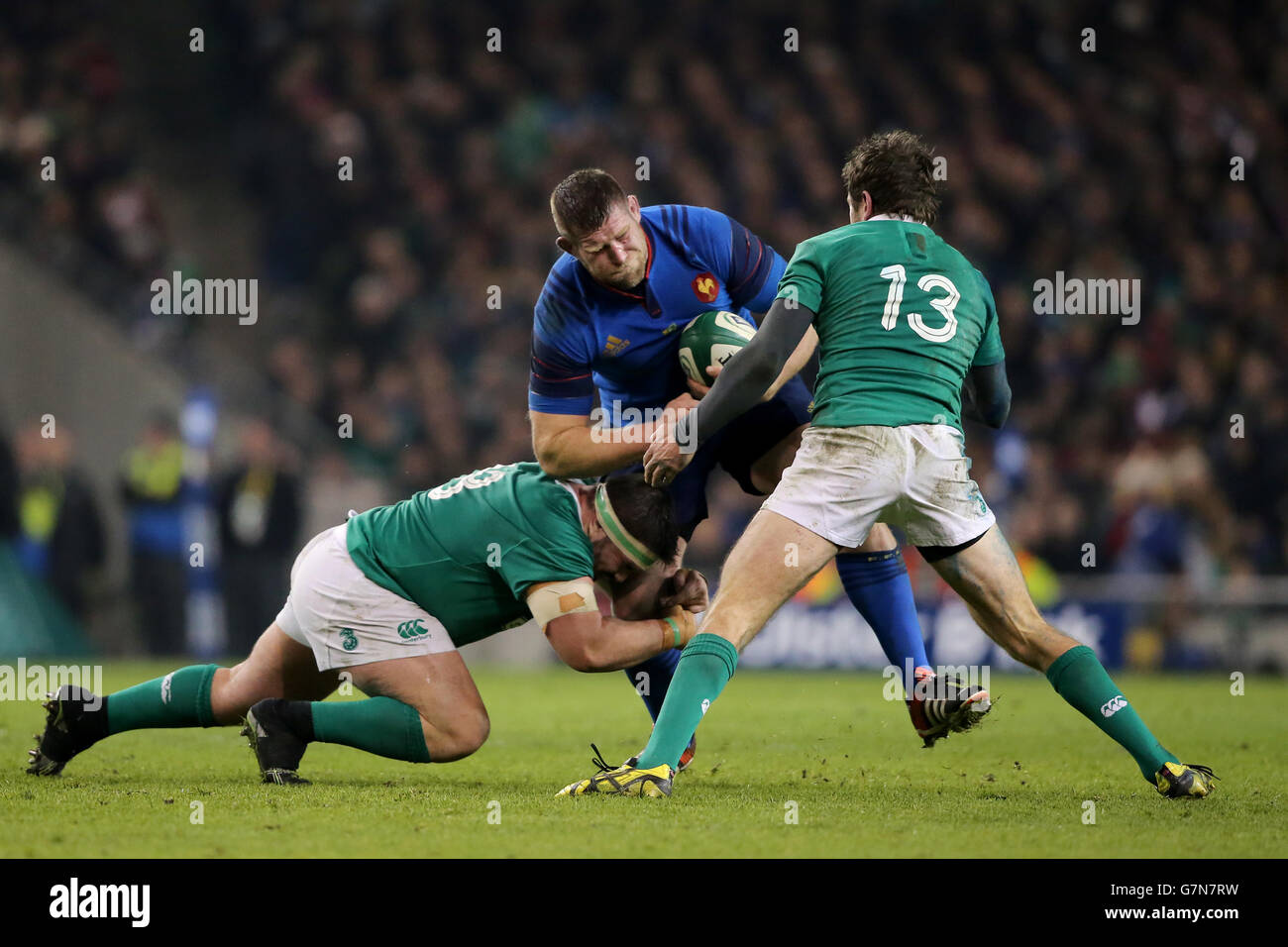 France's Vincent Debaty (centre) is tackled by Ireland's Jared Payne (right) and Martin Moore (floor) during the 6 Nations match at Aviva Stadium, Dublin. Stock Photo