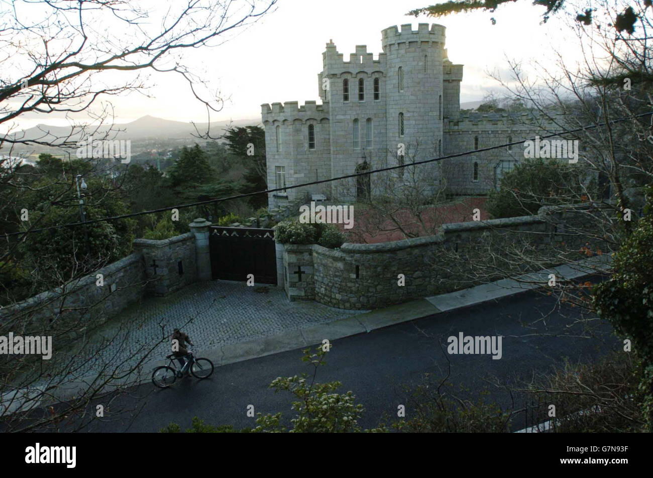A man cycles past a residential castle in Killiney, one of Dublin's most expensive districts, as
