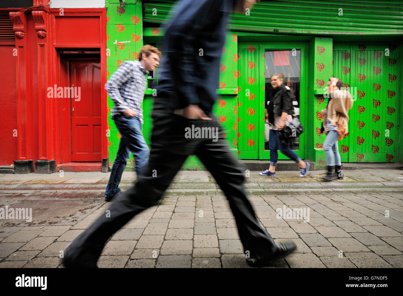 Young Irish people walking on the paved Dame Lane Street in Dublin