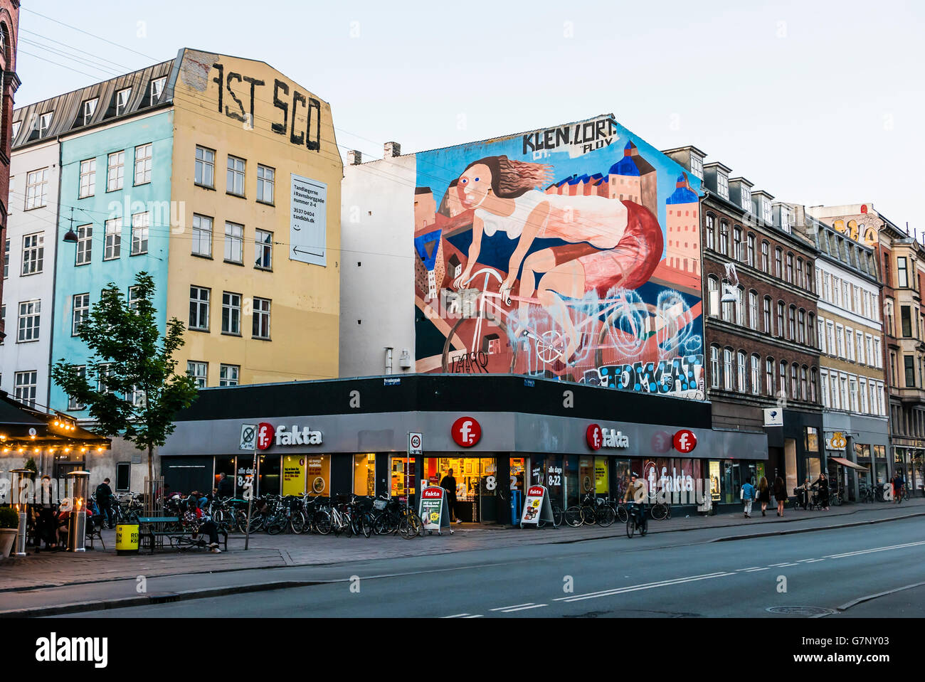 Large graffiti mural of a female cyclist on a wall above a Fakta local supermarket in Copenhagen, Denmark. Stock Photo