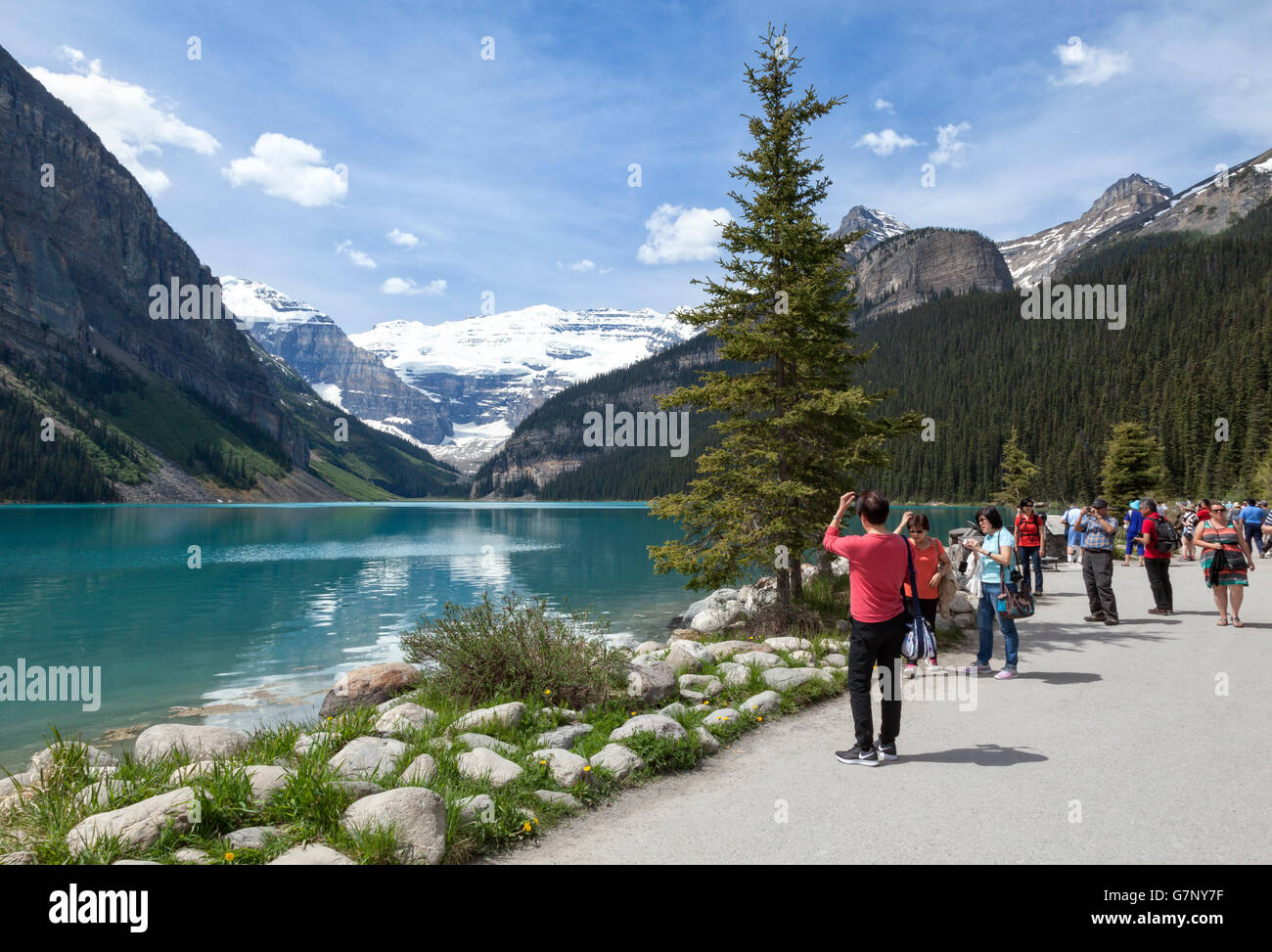 Tourists pause to take in the natural beauty of Lake Louise in Alberta Canada Stock Photo