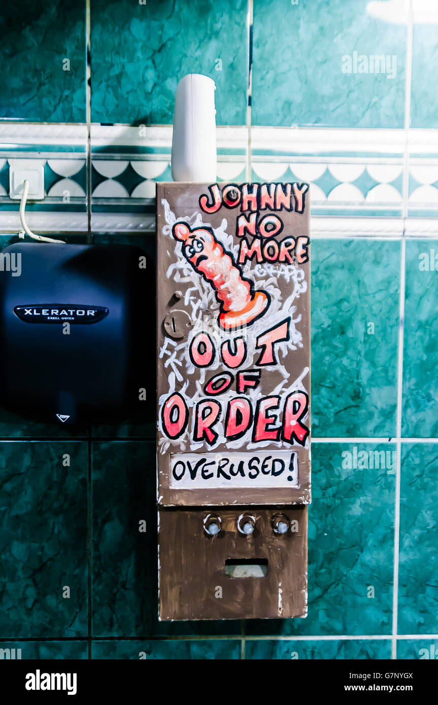 Broken condom machine in a gents' toilet saying 'Johnny no more.  Out of Order.  Overused'. Stock Photo