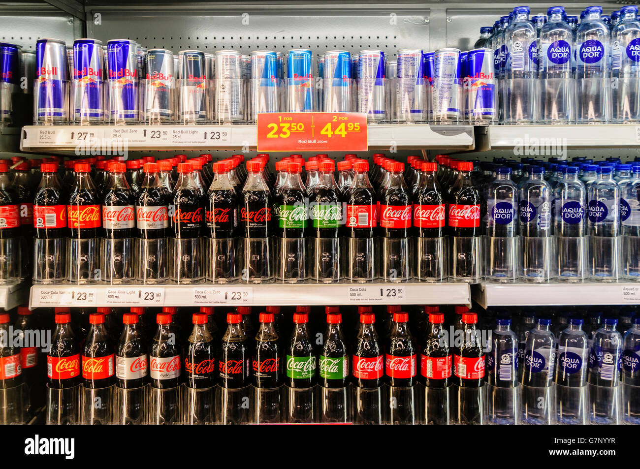 Coca cola (ordinary, diet/light/lite, and life) with Red Bull energy drinks and bottled water for sale in a shop in Denmark. Stock Photo