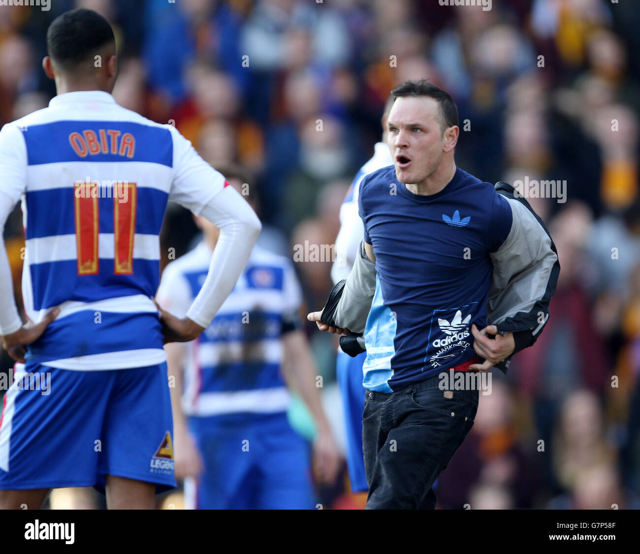 Soccer - FA Cup - Sixth Round - Bradford City v Reading - Valley Parade. A fan invades the pitch to taunt the opposing fans as Reading's Jordan Obita looks on Stock Photo