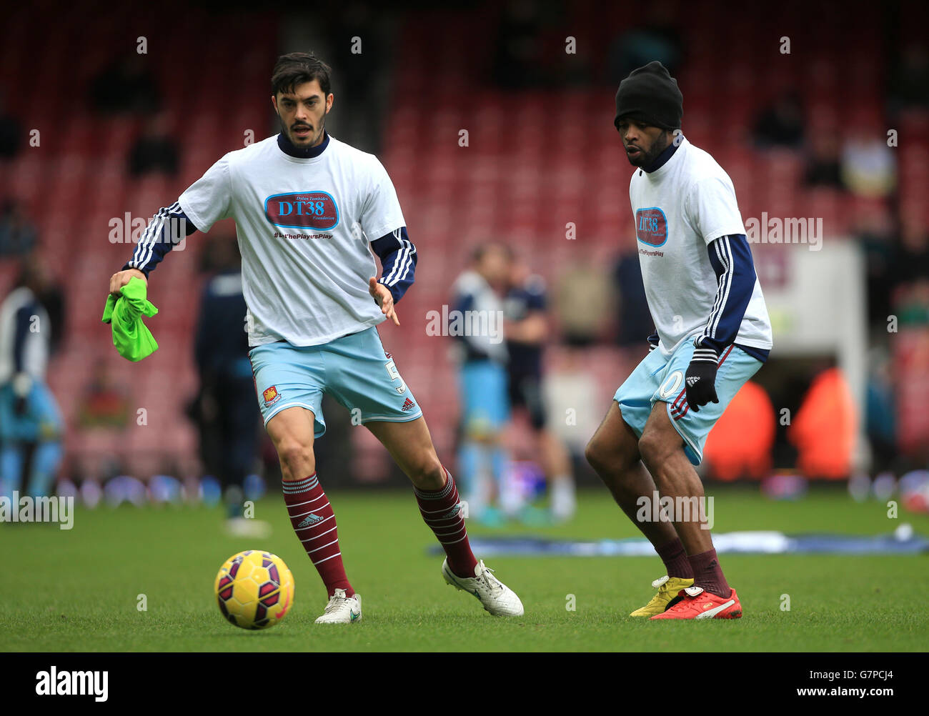 West Ham United's James Tomkins (left) and Alex Song wearing DT38 Foundation T Shirts in memory of former West Ham player Dylan Tombides during the warm up before the Barclays Premier League match at Upton Park, London. PRESS ASSOCIATION Photo. Picture date: Saturday February 28, 2015. See PA story SOCCER West Ham. Photo credit should read: Nick Potts/PA Wire. RESTRICTIONS: Editorial use only. Maximum 45 images during a match. No video emulation or promotion as 'live'. No use in games, competitions, merchandise, betting or single club/player services. No use with unofficial audio, video, Stock Photo