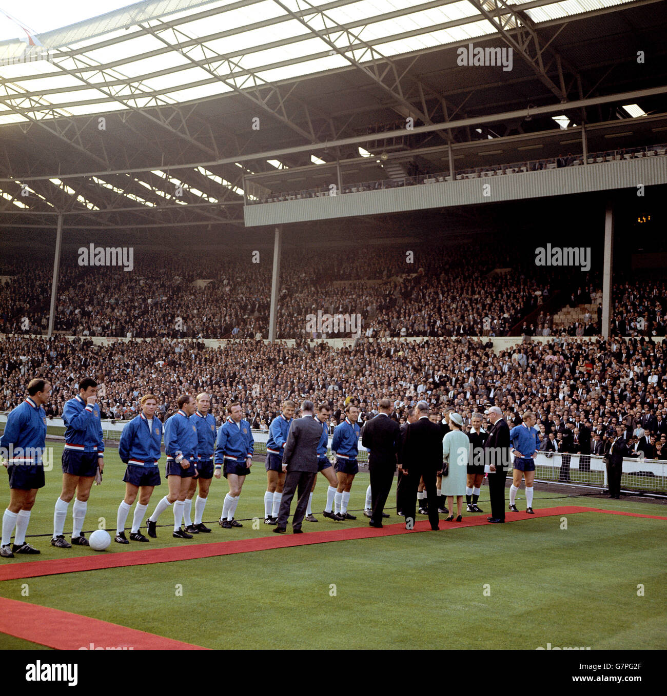 HRH Queen Elizabeth II (fourth r) is introduced to the England team by FIFA President Sir Stanley Rous (second r) before the opening match of the Finals. The England players are (l-r) George Cohen, Gordon Banks, Alan Ball, Ray Wilson, Bobby Charlton, Nobby Stiles, Roger Hunt, John Connelly, Jimmy Greaves, Jack Charlton (hidden), Bobby Moore (far r) Stock Photo