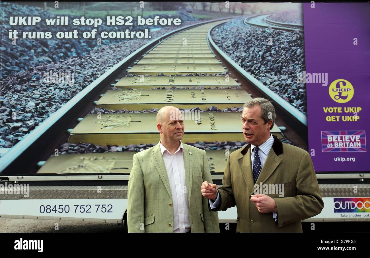 Leader of UKIP Nigel Farage, alongside UKIP Aylesbury Parliamentary candidate Chris Adams as they unveils a UKIP election poster stating the parties opposition to HS2, at Wendover train station in Buckinghamshire. Stock Photo