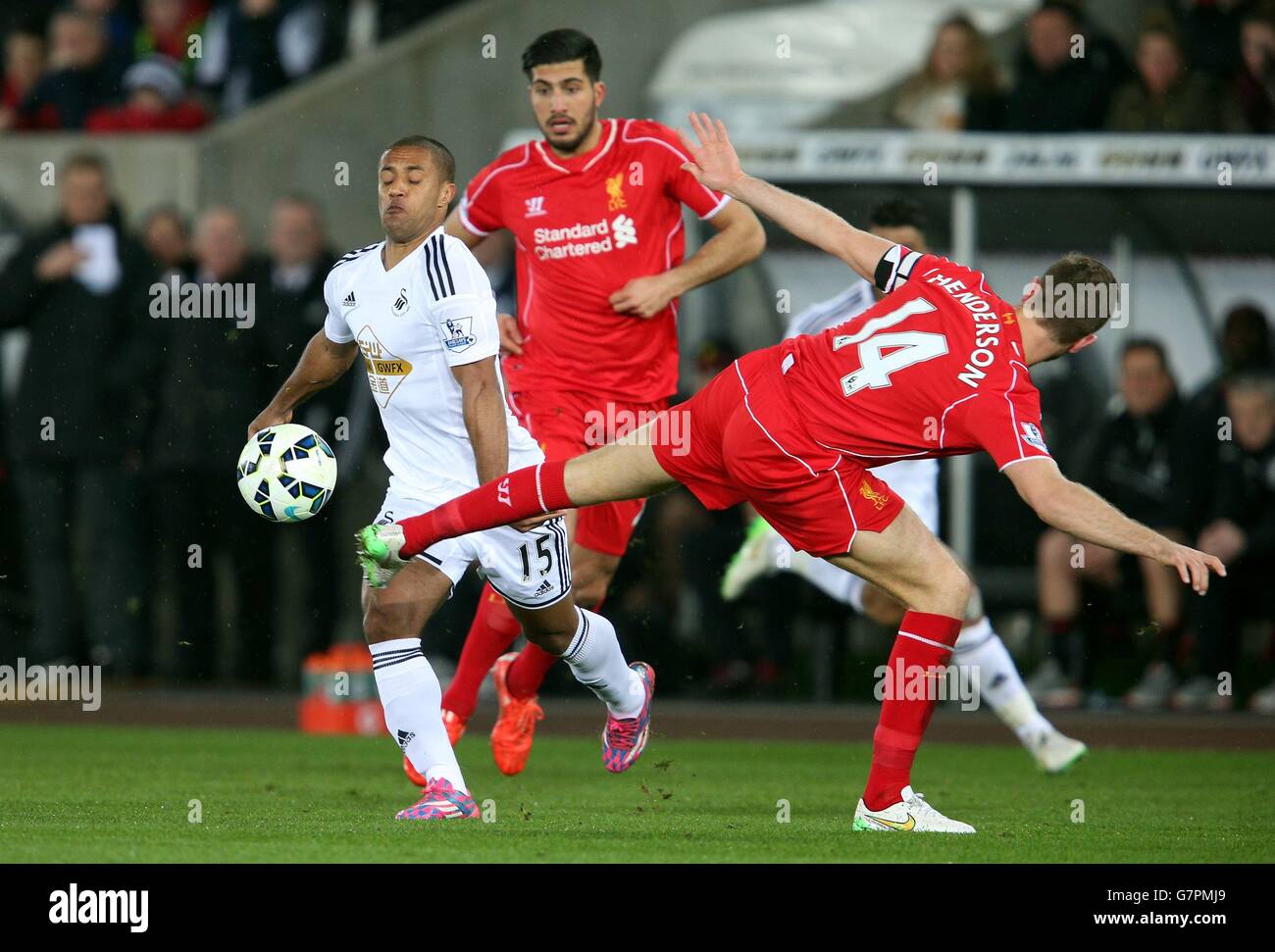 Swansea City's Wayne Routledge is tackled by Liverpool's Jordan Henderson during the Barclays Premier League match at the Liberty Stadium, Swansea. Stock Photo