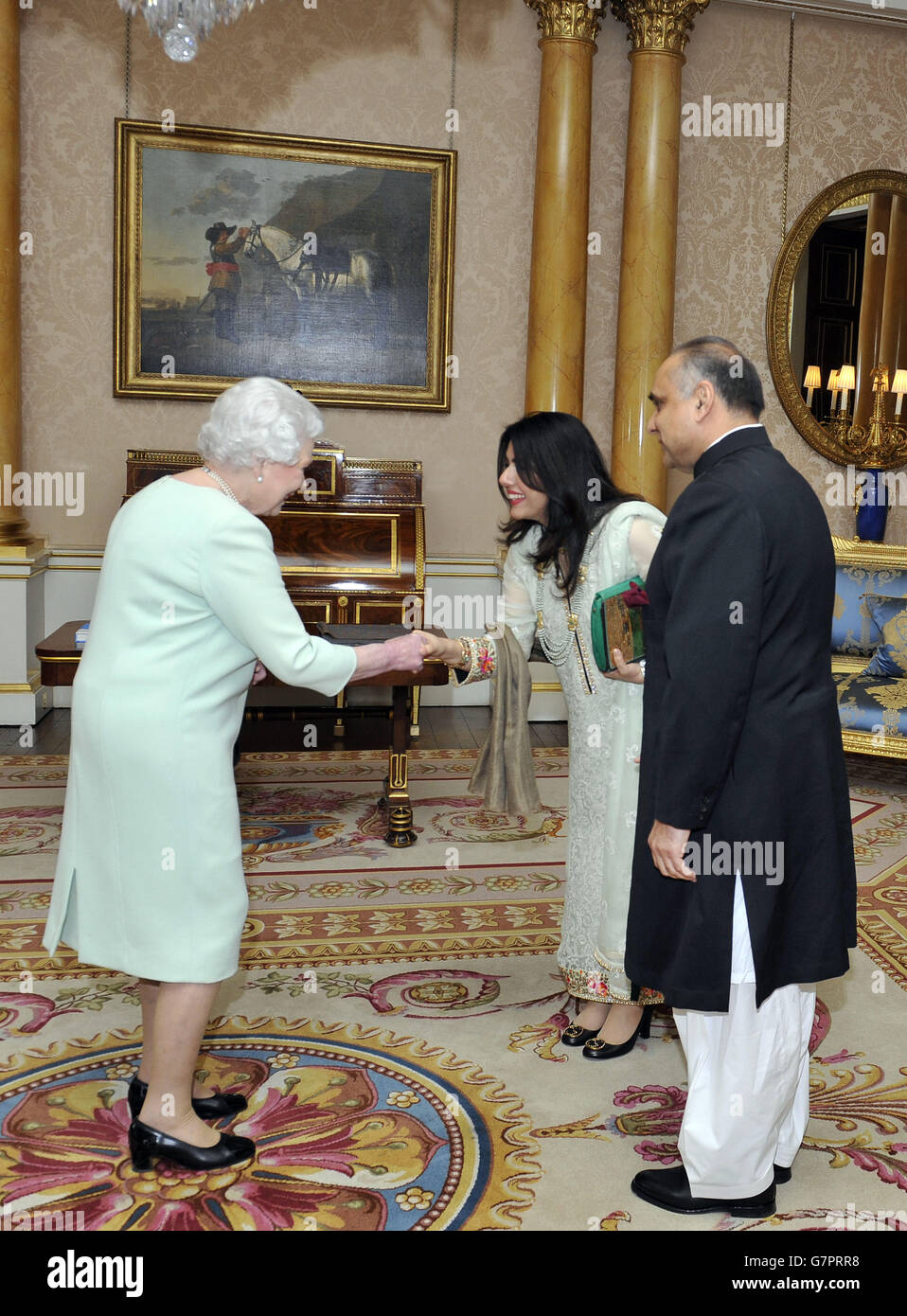 Queen Elizabeth II (left) is greeted by Mrs Abbas after His Excellency Mr Syed Ibne Abbas presented the Letters of Recall of his predecessor and his own Letters of Commission as High Commissioner for the Islamic Republic of Pakistan in London, during an audience with the Queen at Buckingham Palace, London. Stock Photo