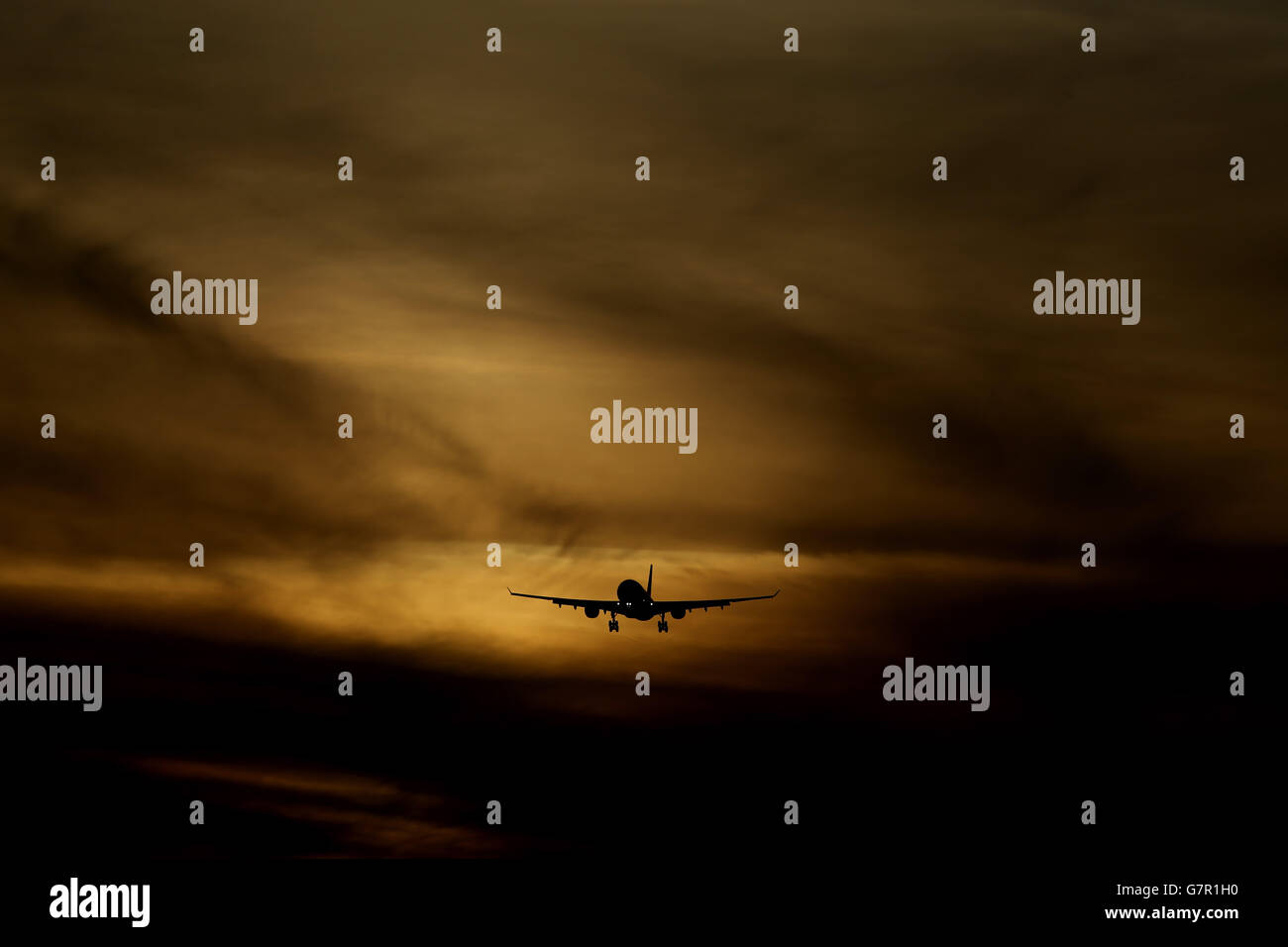A plane coming in to land at dusk at Heathrow Airport. Stock Photo