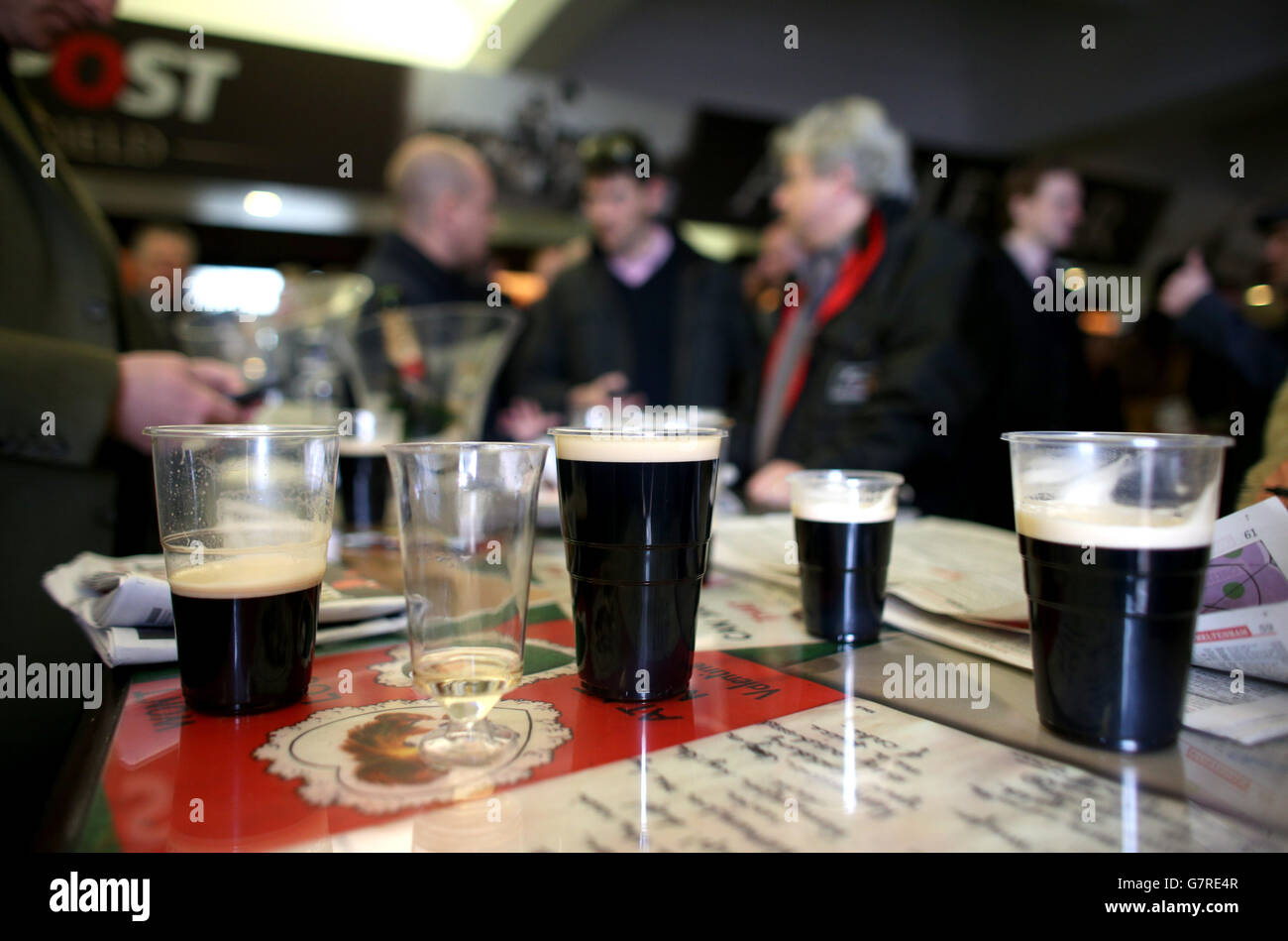Racegoers enjoy a drink as they check the form guides on St Patrick's ...