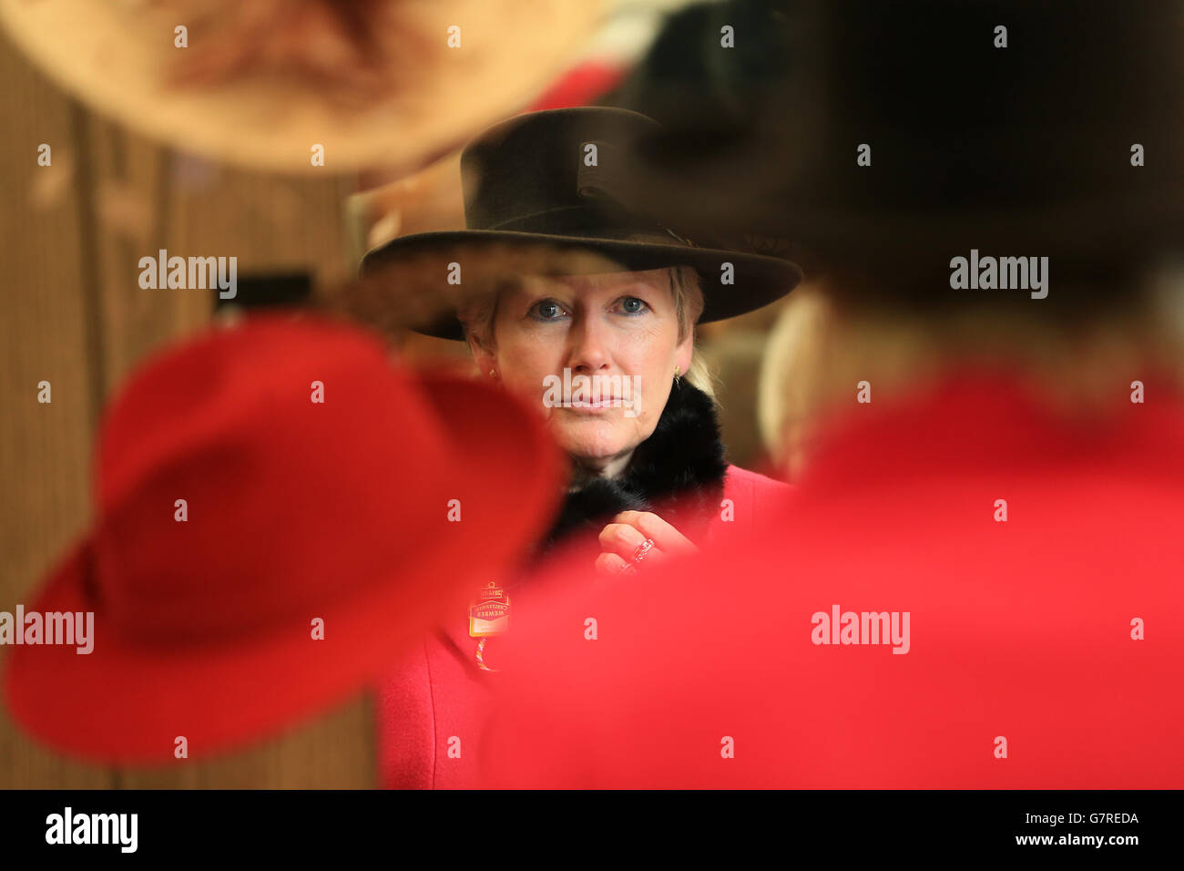 Horse Racing - 2015 Cheltenham Festival - Ladies Day - Cheltenham Racecourse. A racegoer tries on a hat for size from a stall in the tented village at Cheltenham Racecourse Stock Photo