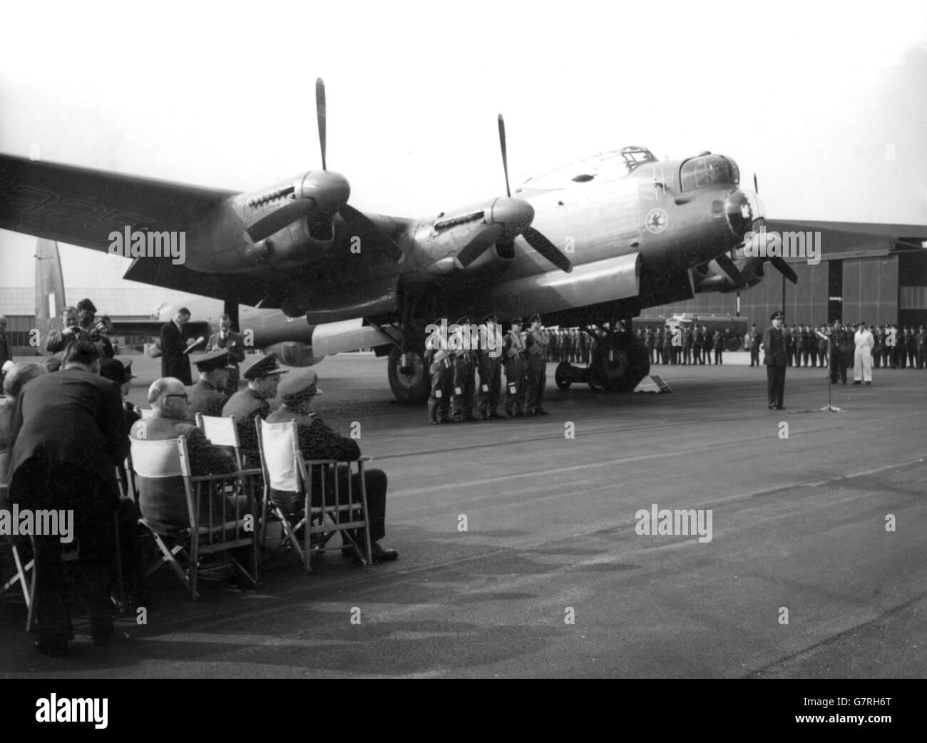 The Leave-taking ceremony under the shadow of the last of the Lancasters at St. Mawgan Coastal Command Station, Cornwall. Air Marshall Sir Bryan Reynolds, Coastal Command, gave the valedictory address. Bomber pilots who had flown the Lancaster raids, and high-ranking RAF officers attended as the plane flew away to the breakers yards. The four-engined Lancaster D for Delta, was withdrawn from Bomber Command in 1953 and has since then been flown by crews from Coastal Command. The Lancaster Bombers flew more than 156,000 sorties in the WWII and dropped over 600,000 tons of high explosive bombs. Stock Photo