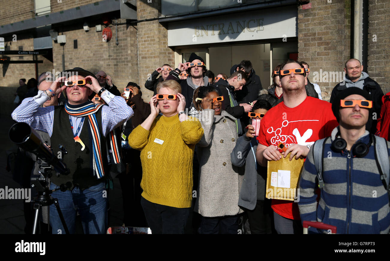 People watch an eclipse of the sun outside the Broadmarsh Shopping Centre, in Nottingham, as a near-total eclipse of the sun is set to thrill or disappoint millions today, depending on luck and the fickle British weather. Stock Photo