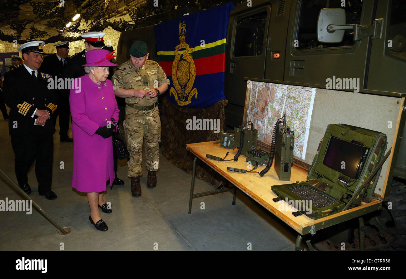 Queen Elizabeth II is shown military equipment by Corporal Richard Molyneux (right) on board HMS Ocean, at HM Naval Base Devonport, in Plymouth, Devon. Stock Photo