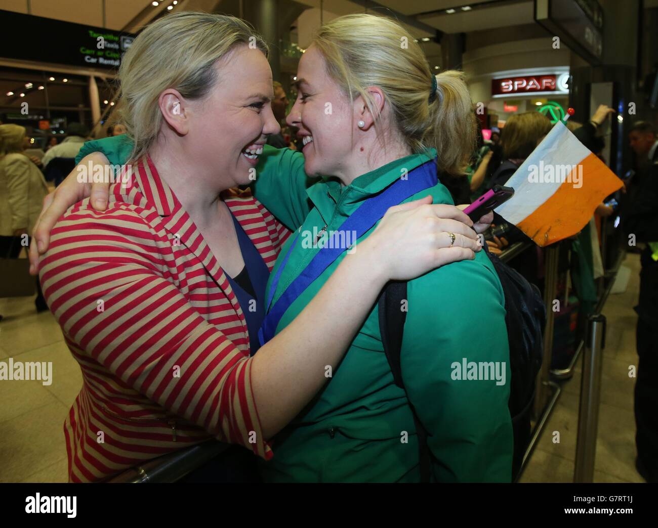 Ireland's womens' rugby captain Niamh Briggs celebrates with her childhood friend, Edel Fitzsimons (left), as the team arrives at Dublin airport after winning the Six Nations trophy in a 73-3 victory over Scotland in Glasgow. Stock Photo