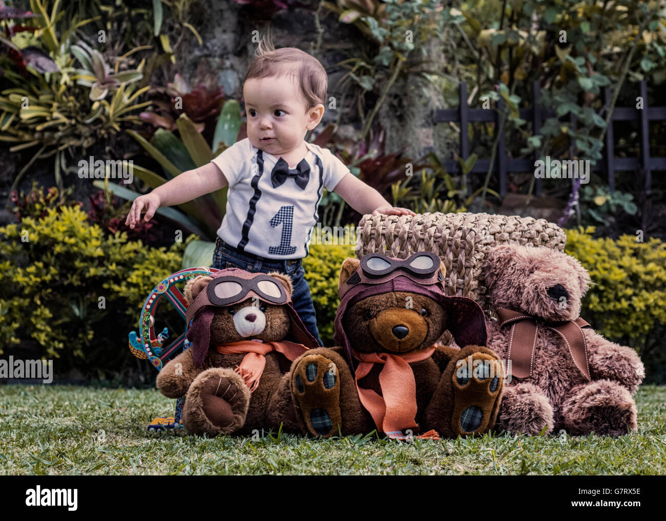 Baby boy playing with teddy bears at the garden, learning to walk Stock Photo