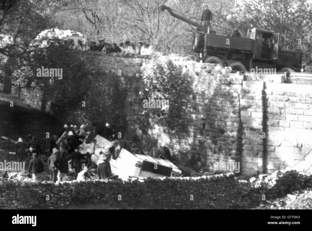 Rescue workers search the wrecked coach, carrying a party of women on a day's sightseeing trip, after it broke through the parapet of Dibbles Bridge at Hebden, Yorkshire. The coach plunged nearly 20 feet into a field and rolled onto it's roof. 32 people were killed. Stock Photo