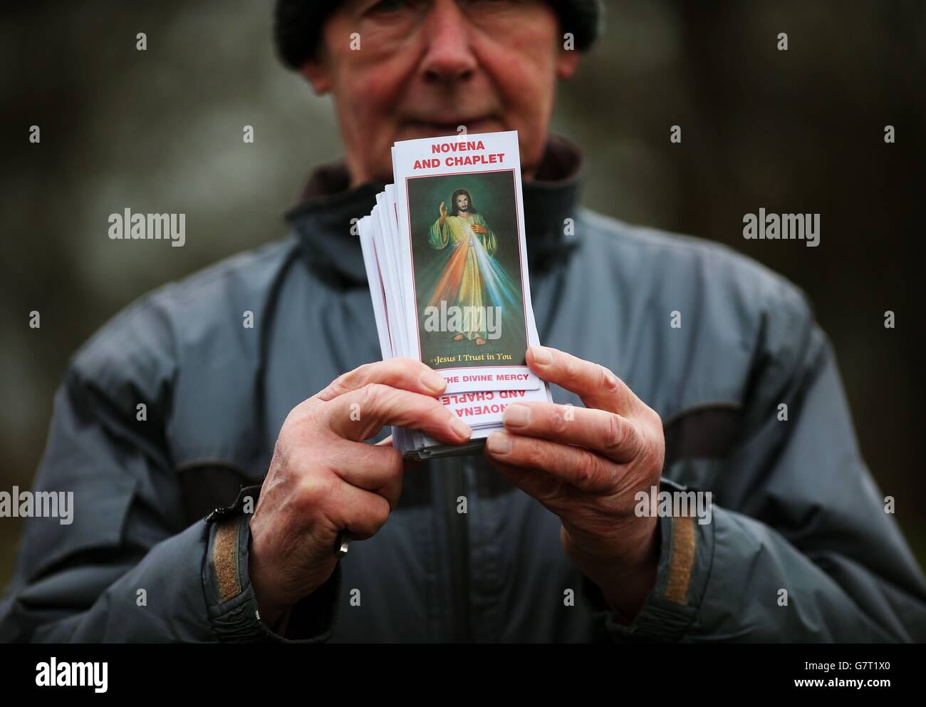 A man holds a copy of the Divine Mercy Novena and Chaplet during the annual Good Friday 'Way of the Cross' procession from the Wellington Monument to the Papal Cross in the Phoenix Park, Dublin. Stock Photo