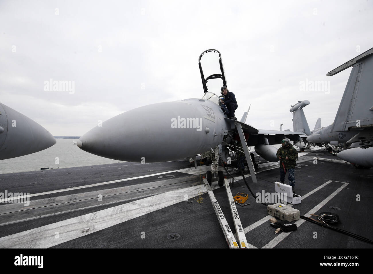 US naval personnel work onboard the US aircraft carrier USS Theodore Roosevelt, currently at anchor off the UK's south coast as it is too big to enter one of the Royal Navy's major bases, the carrier, one of ten Nimitz class aircraft carriers in the US fleet, arrived at Portsmouth, Hampshire, yesterday for a five-day visit. Stock Photo