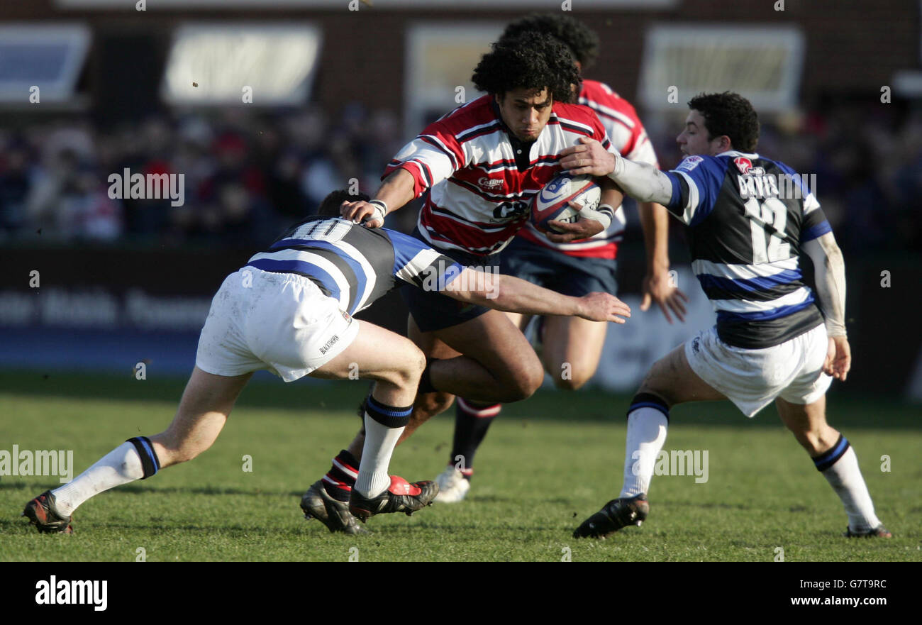 Gloucester's Terry Fanolua (C) breaks through the tackle of Bath's Chris Malone (L) and Ryan Davis Stock Photo