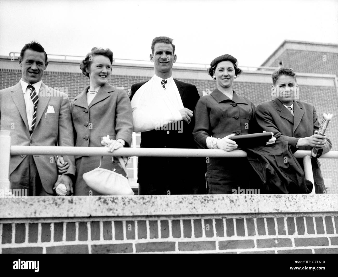 Jack Burkitt, captain of the Cup-wining Nottingham Forest team, has his arm in a sling from a Wembley injury, but that doesn't stop him taking the air with his wife and son, Roger, and team-mate Billy Gray (l) and Mrs Gray (second left) at Hove in Sussex. The Nottingham Forest team spent a day on the Sussex coast before their return home. Stock Photo