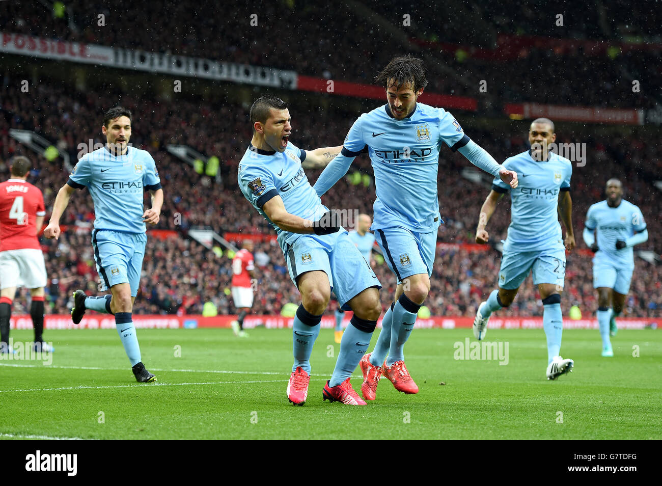 Manchester City's Sergio Aguero (centre) celebrates scoring their first goal of the game with team-mate David Silva during the Barclays Premier League match at Old Trafford, Manchester. PRESS ASSOCIATION Photo. Picture date: Sunday April 12, 2015. See PA story SOCCER Man Utd. Photo credit should read: Martin Rickett/PA Wire. . . Stock Photo