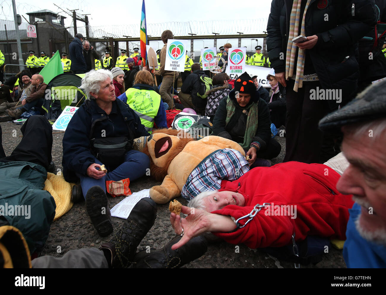 Anti-Trident demonstrators sit in the road at the entrance at the North Gate at HM Naval Base Clyde, Faslane. Stock Photo