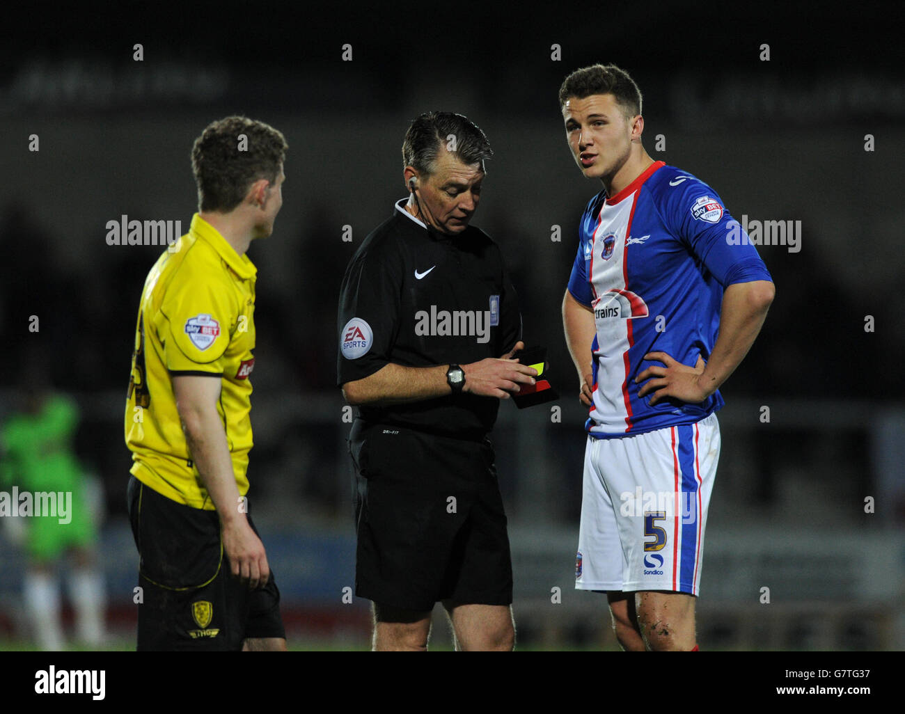 Carlisle's Nathan Buddle (right) receives a yellow card for a tackle on Burton Albion's Matty Palmer during the Sky Bet League Two match at the Pirelli Stadium, Burton. Stock Photo