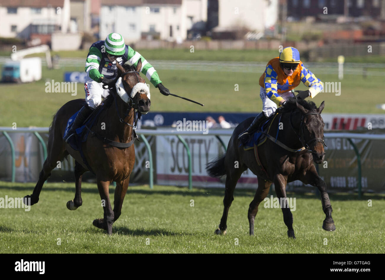 Rascal ridden by Harry Skelton (left) on their way to winning the Ayrshire Hospice Making Today Matter Handicap Hurdle during the 2015 Coral Scottish Grand National Festival at Ayr Racecourse. Stock Photo