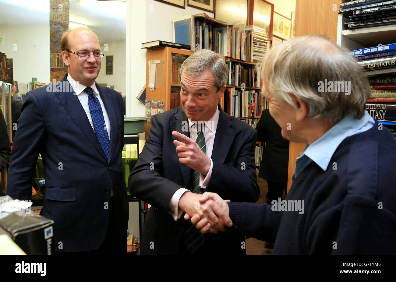 Ukip Leader Nigel Farage (centre) accompanied by Mark Reckless (left), Ukip candidate for Rochester and Strood, shakes the hand of Bob Peters from City Books shop in Rochester High Street, Kent, during a general election campaign walk about. Stock Photo