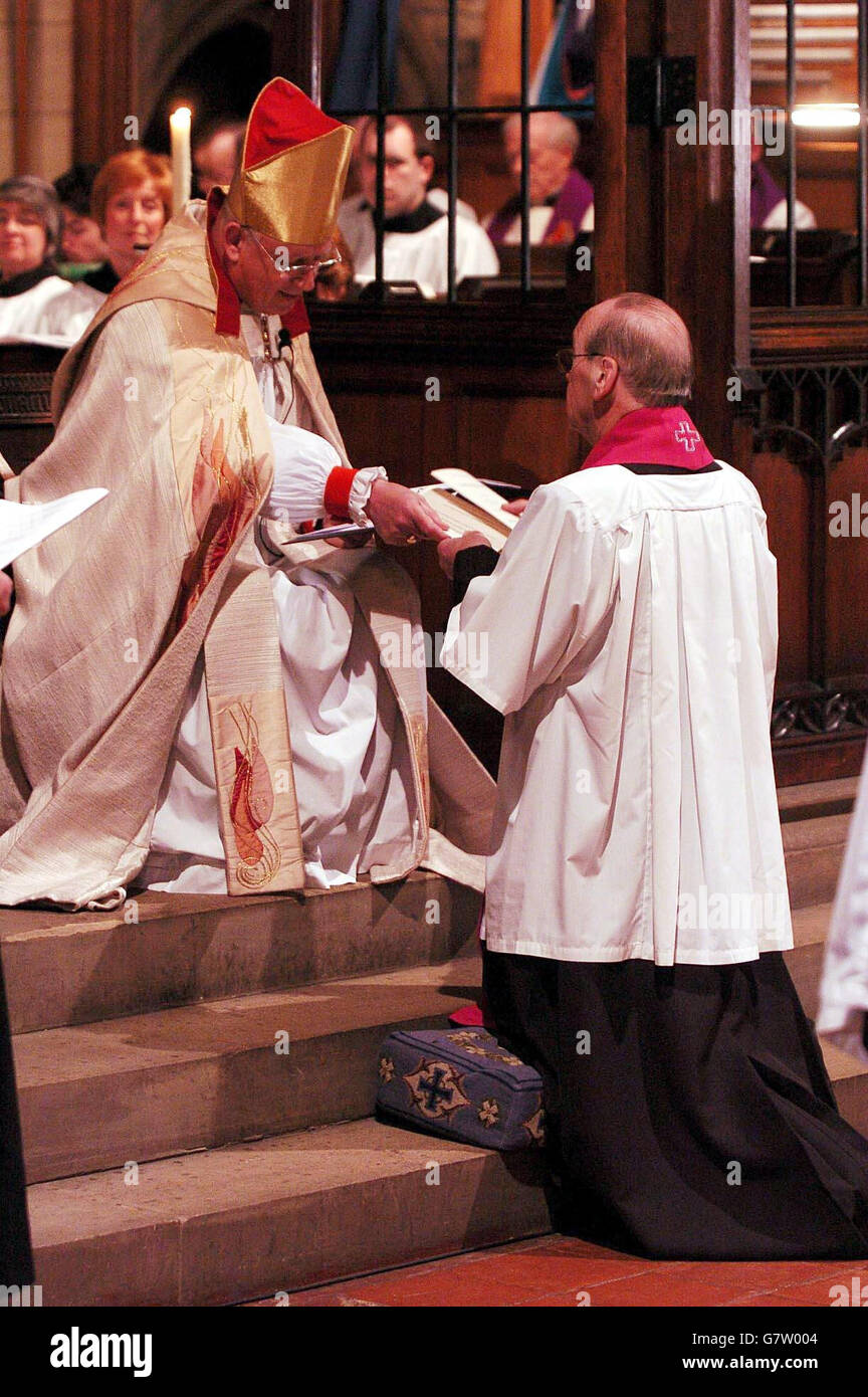 Dr David Hope, the former Archbishop of York, kneels before the Bishop of Bradford, David James, at the service of licensing in St Margaret's Church, Ilkley, where he was officially appointed as their parish priest. Stock Photo