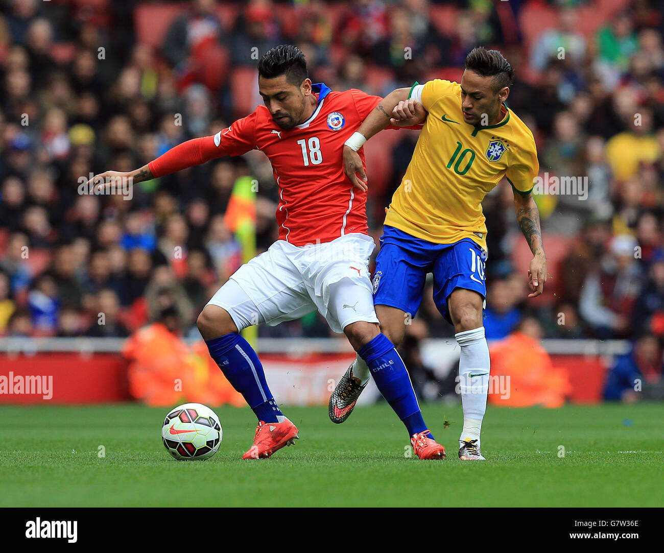 Soccer - International Friendly - Brazil v Chile - Emirates Stadium. Chile's Gonzalo Jara is challenged by Brazil's Neymar (right) during the International Friendly at the Emirates Stadium, London. Stock Photo