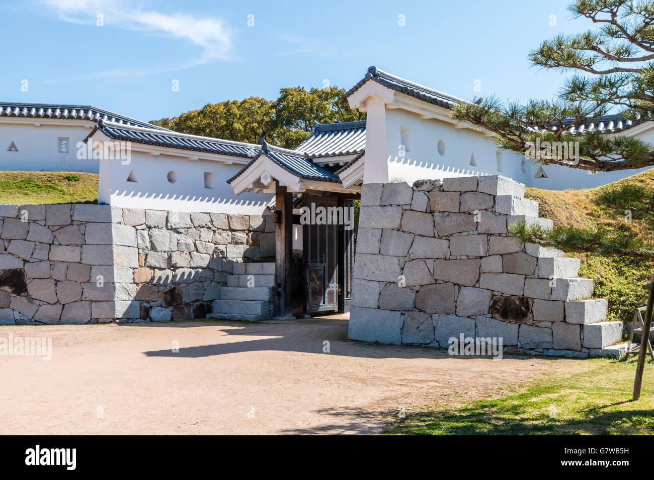 Japan, Ako castle. Koraimon type gate, the Umayaguchimon gate with defending stone and plaster dobei walls. Sunshine. Daytime. Blue sky. Stock Photo