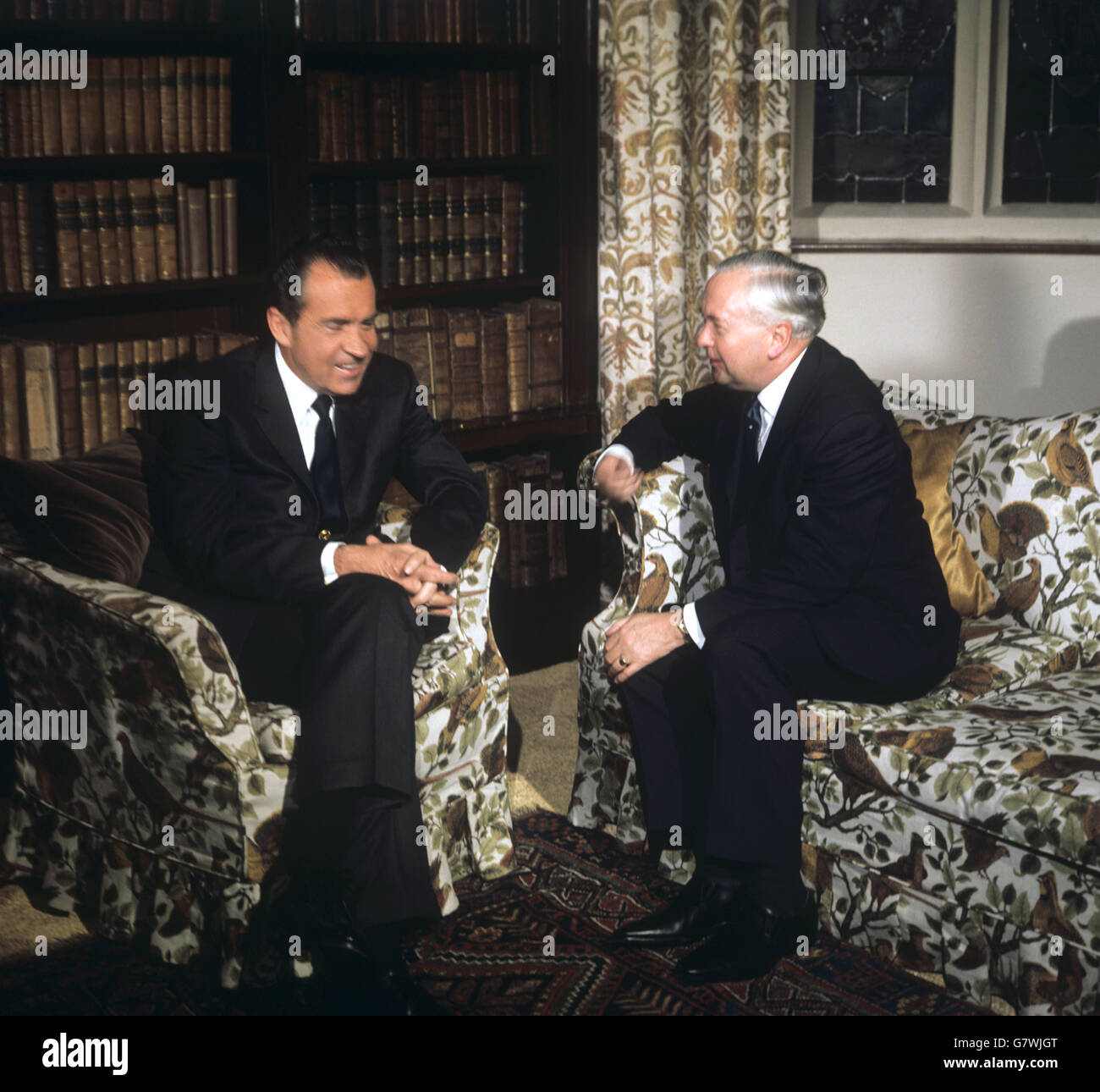 Richard Nixon, the American President, listens as Britain's Prime Minister Harold Wilson, hands clasped around his knee, talks on a seat in front of the massive fireplace in the Great Hall of Chequers, the Prime Minister's official country residence in Buckinghamshire. Mr Nixon had driven directly to Chequers from Heathrow Airport, where he arrived on his European Tour. Stock Photo