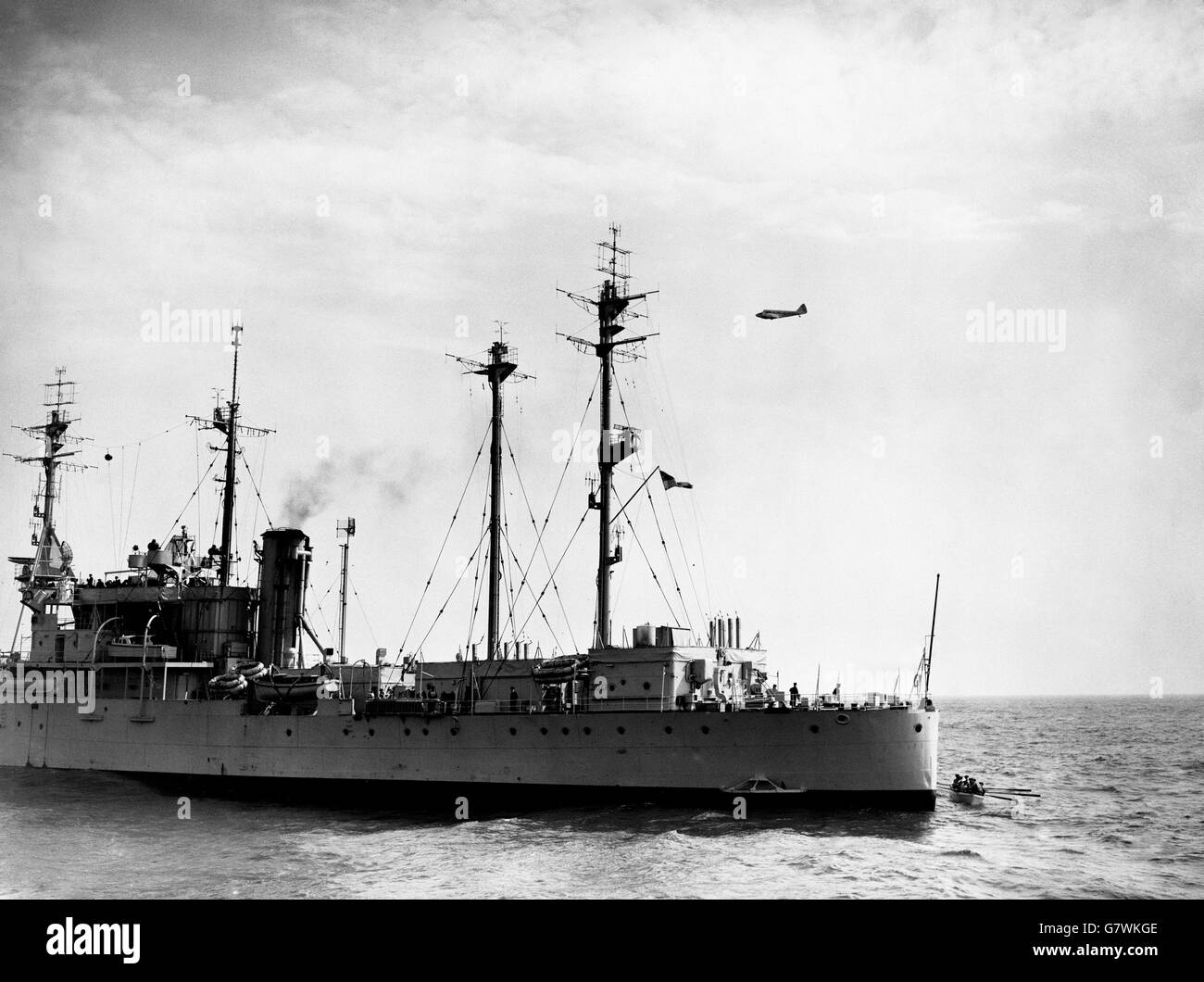 An aircraft passes the Royal Navy radar ship HMS Boxer, during the search for sunken submarine HMS Affray. The Boxer is at the centre of the search operations in the English Channel for the exact position of the Affray, and for any survivors who may have left the submarine by means of their escape apparatus. The Affray had 75 men on board. Stock Photo