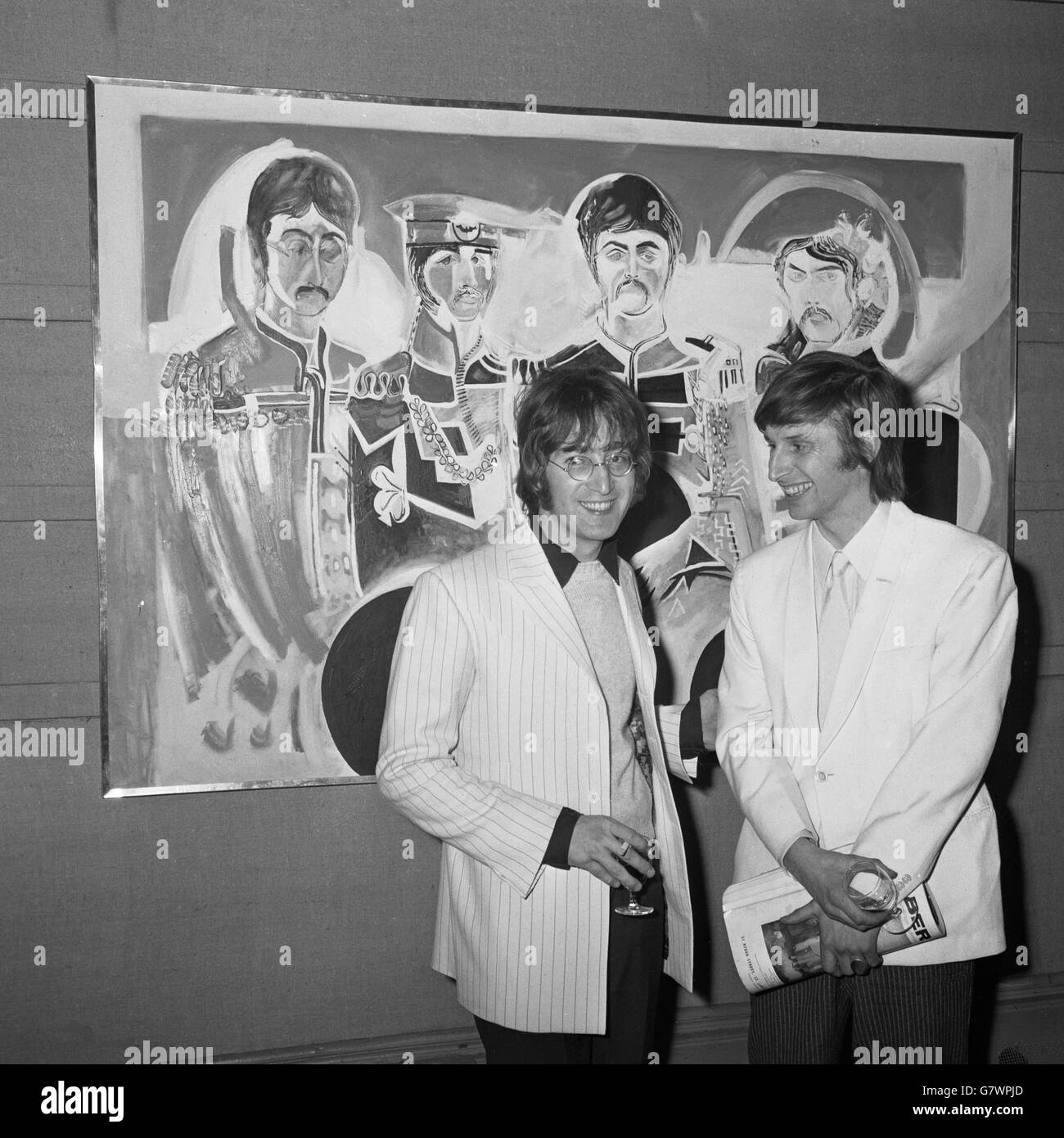 Bespectacled JOHN LENNON of The Beatles with JONATHAN HAGUE,21-year-old artist from Llandudno,seen against a picture of The Beatles, the work of Jonathan, at an exhibition of his work which opened at London's Royal Institute Galleries to-day (Monday). The Beatles John Lennon and Paul McCartney sponsored the exhibition because Jonathan (Jon) was their friend. He attended the same Liverpool College of Art as John Lennon for three years. His paintings are large, colourful, basically figurative and highly original. Stock Photo