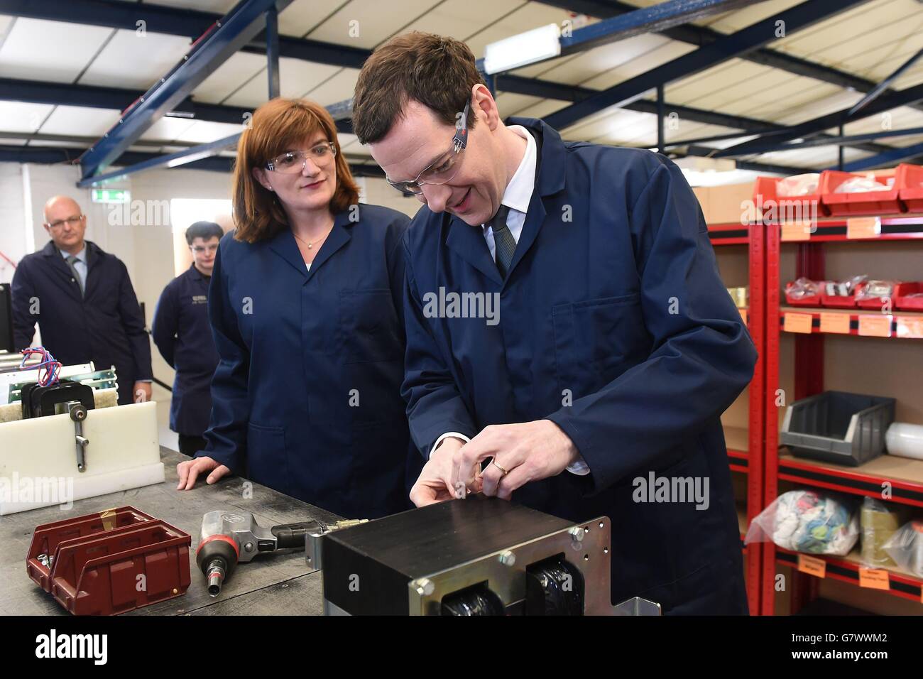Chancellor George Osborne tightens a nut, with Secretary of State for Education Nicky Morgan (left) during a visit to EPS engineering company in Loughborough, Leicestershire. Stock Photo