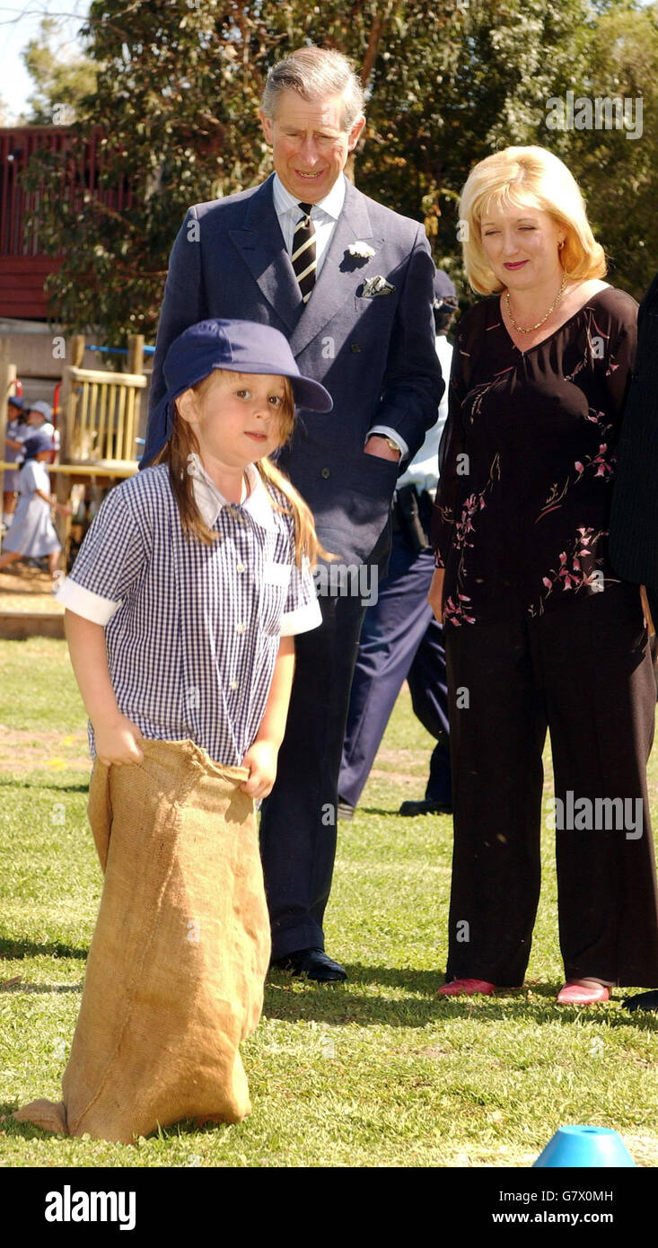 The Prince of Wales and headmistress Tracy Hammill, watch Suzy Beers, 5, take part in a sack race at Coburg North primary school, in the suburbs of Melbourne. Charles also visited Geelong Grammar School, where he spent two terms as a pupil in 1966, during a tour of Australia's second city. Stock Photo