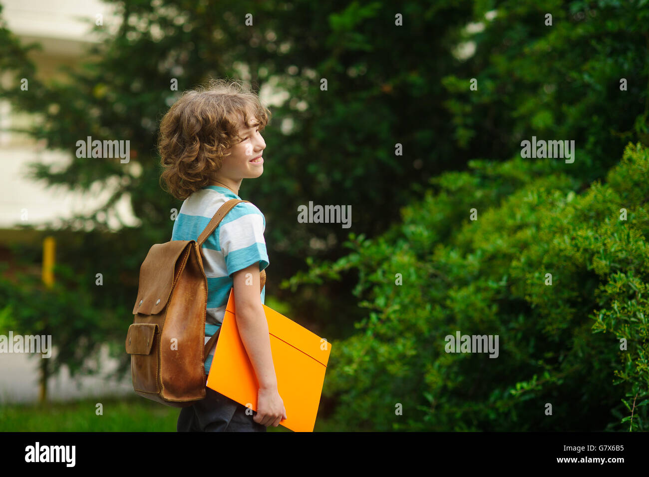 First grader with a school backpack behind the back. The school student ...