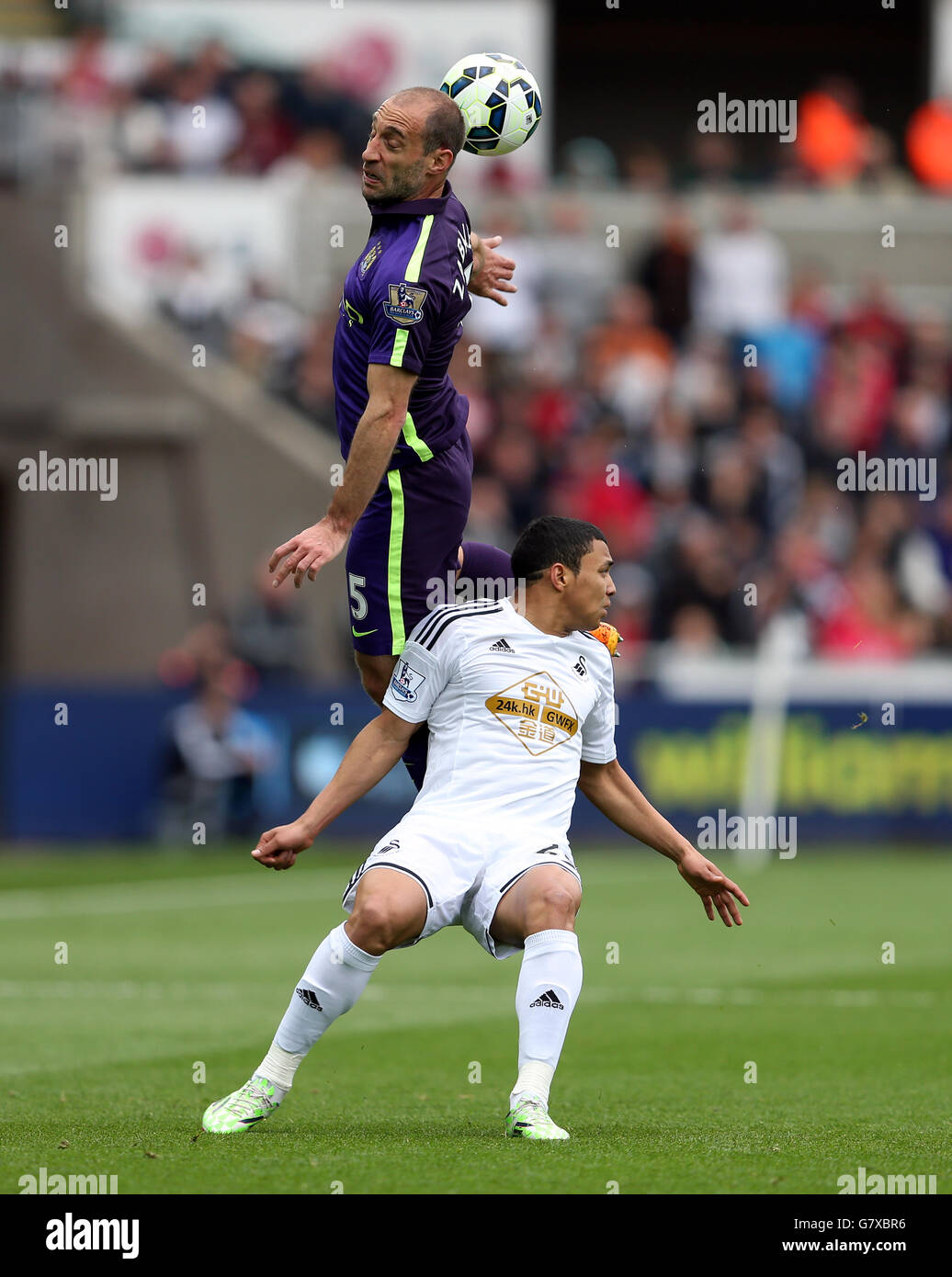 Manchester City's Pablo Zabaleta (top) and Swansea City's Jefferson Montero battle for the ball during the Barclays Premier League match at the Liberty Stadium, Swansea. Stock Photo