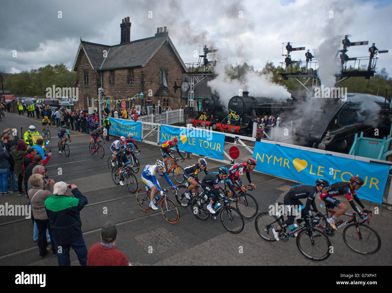 The peloton crosses the North Yorkshire Moors Railway line at Grosmont crossing during the Tour de Yorkshire between Bridlington and Scarborough. Stock Photo