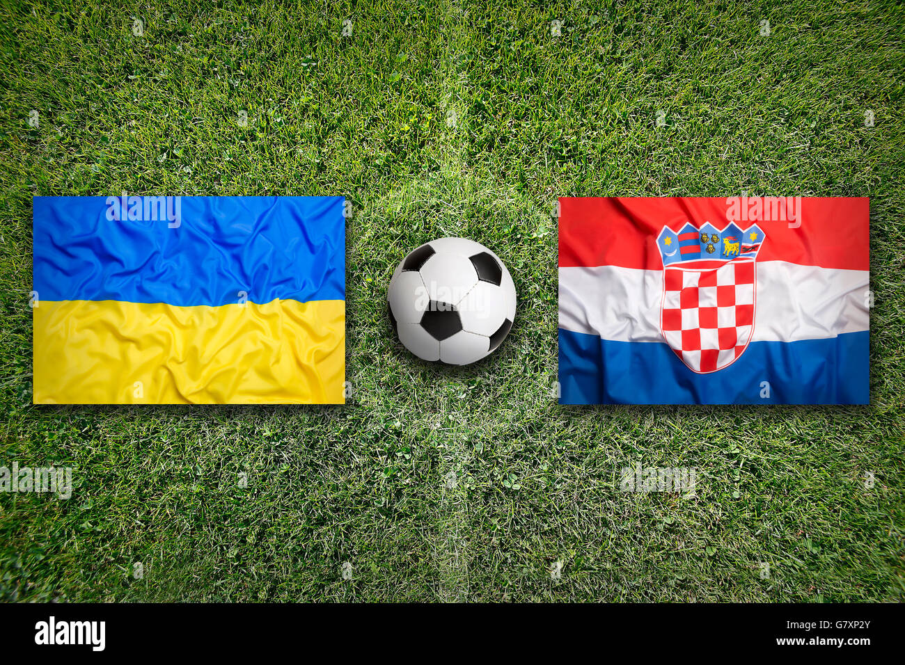Ukraine vs. Croatia flags on green soccer field Stock Photo